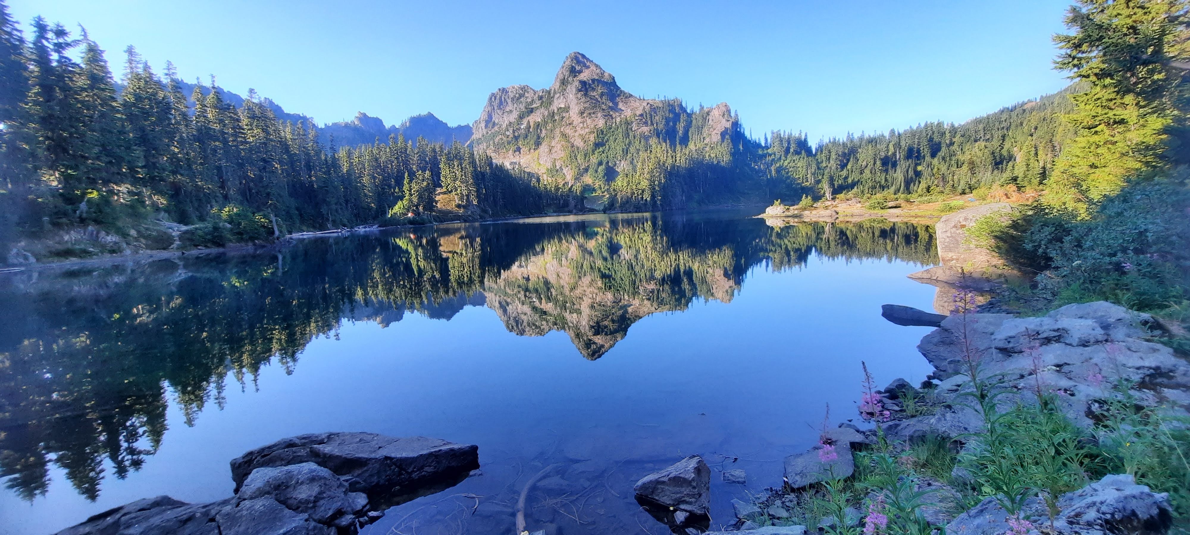 a sunny day on top of a mountain at a lake. It is serene